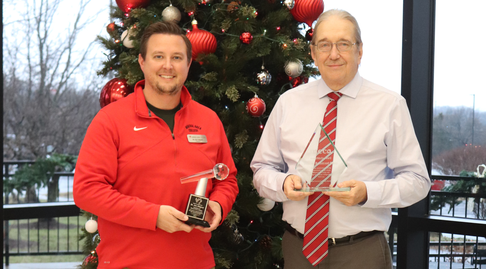 Image of Dr. Gilgour and Mr. Dockins accepting awards in front of a Christmas tree.