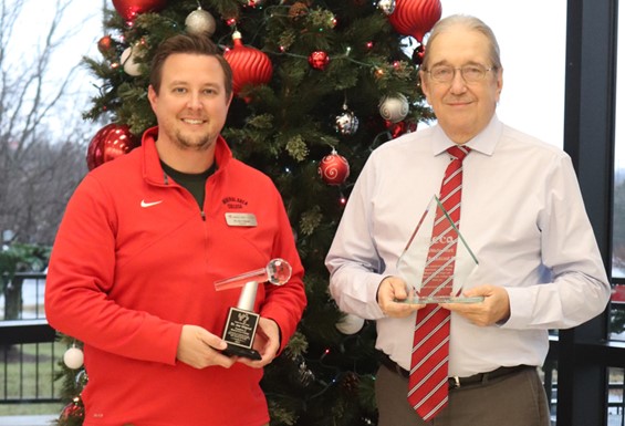 Image of Dr. Gilgour and Mr. Dockins accepting awards in front of a Christmas tree.