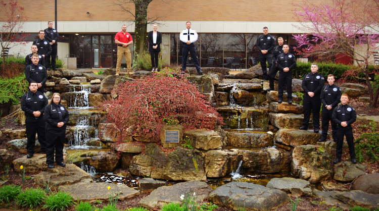 Image of Law enforcement academy standing in front of the quad waterfall. 