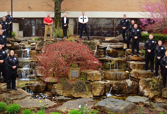 Image of Law enforcement academy standing in front of the quad waterfall. 