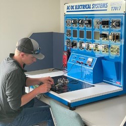 Student working on a machine in a classroom.