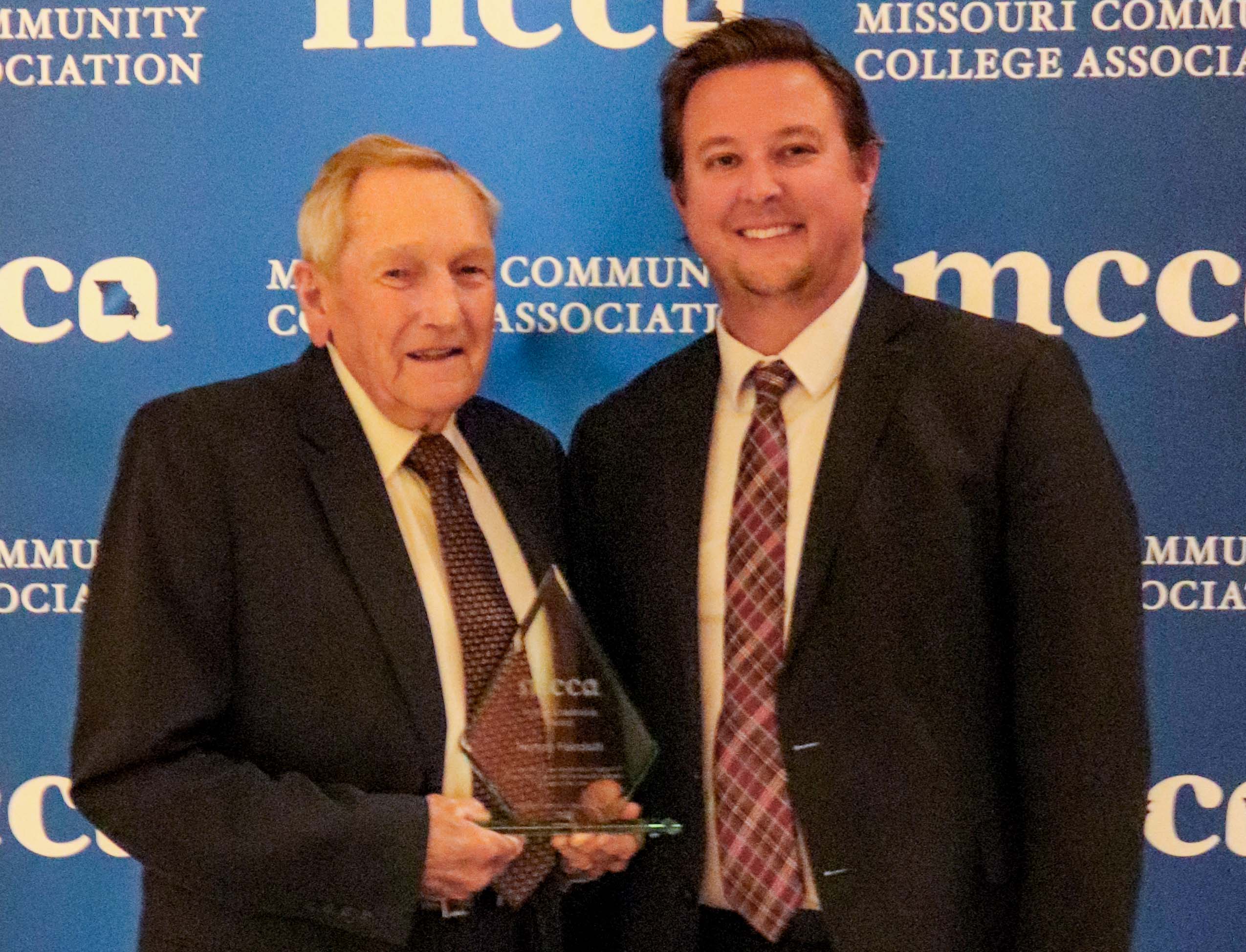 Photo of Harvey Faircloth and Dr. Joe Gilgour in front of MCCA backdrop