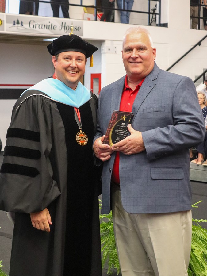 Dr. Joe Gilgour presents the N. Gayle and Rowena Simmons Distinguished Service Award to Tony Myers at the 2024 Commencement Ceremony