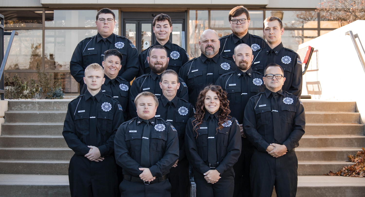 Photo of thirteen graduates of MACLEA Class 25-112 outside on steps