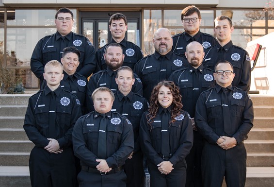 Photo of thirteen graduates of MACLEA Class 25-112 outside on steps
