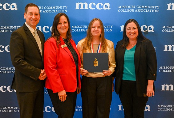 Dr. Keith Zoromski, Dean Julie Sheets, Ashley Edgar, and Alison Sheets in front of MCCA photo backdrop