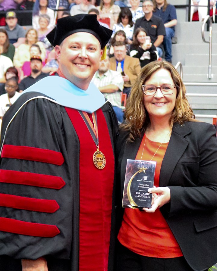 Dr. Joe Gilgour presents Dr. Jamie LaMonds with the Distinguished Alumni Award at the 2026 Commencement Ceremony